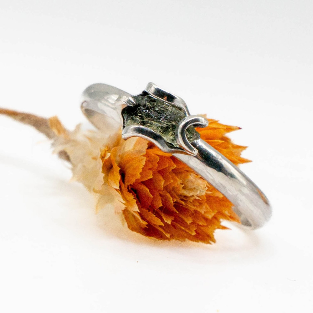 A small, delicate silver ring with moldavite — a tiny talisman